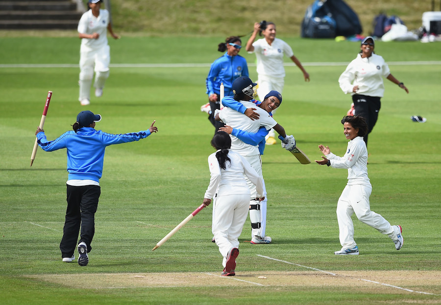 The India players run to the pitch to celebrate their win