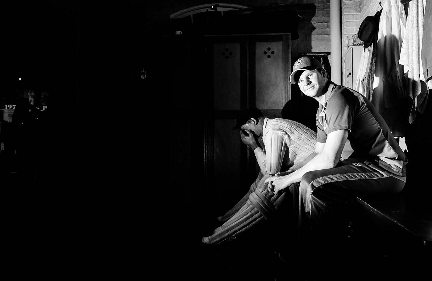 Steven Smith sits next to a statue of Don Bradman