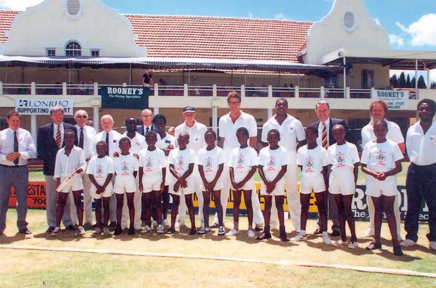 Mike Atherton (back row, in cap) at the Harare Sports Club with a young Patrick Gada (front row, holding miniature bat) and coach Lazarus Zizhou (back row, fifth from left, with hands on a boy's shoulders)