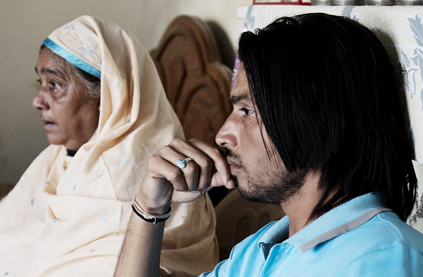 Amir's mother and brother Ejaz watch the news of the sentencing proceedings in London, November 2011