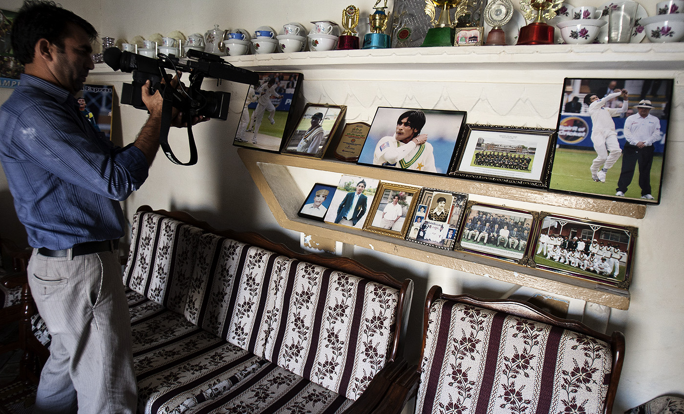 Back to the wall: a TV cameraperson shoots inside Amir's Changa Bangial home after he was sentenced in London