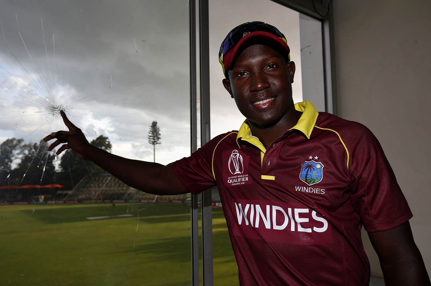Rovman Powell poses by a window he broke at the Harare Sports Club