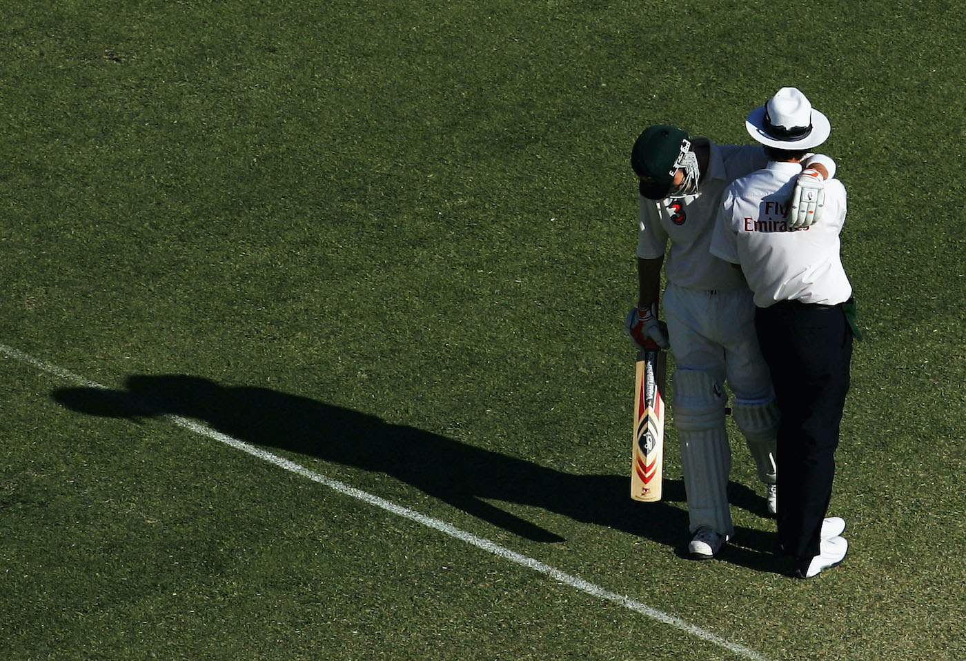 Lean in: Damien Martyn drapes himself on Billy Bowden